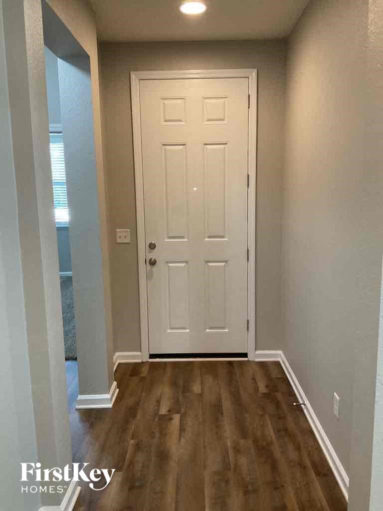 a hallway with a white door and wooden floors