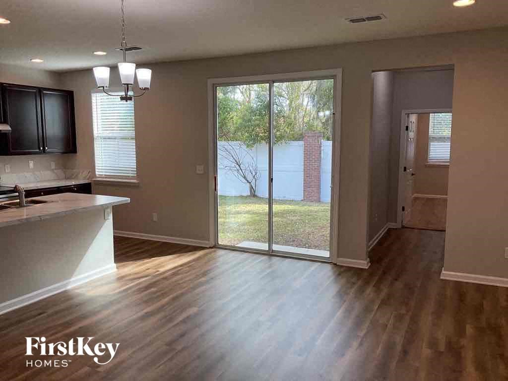 an empty living room with a sliding glass door to a yard