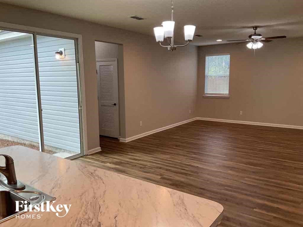 an empty living room with wood flooring and a sliding glass door