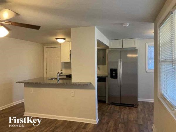 A kitchen with a refrigerator, sink, and cabinets.