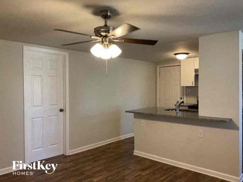 A kitchen area with a counter and a ceiling fan.