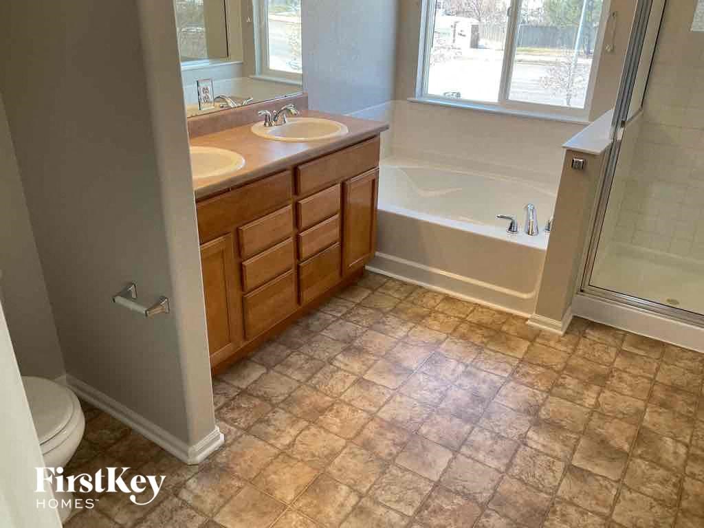 a bathroom with two sinks and a tub and a shower