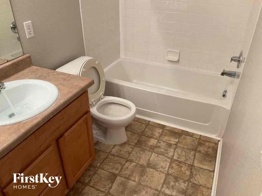 a bathroom with a toilet and a tub and a sink