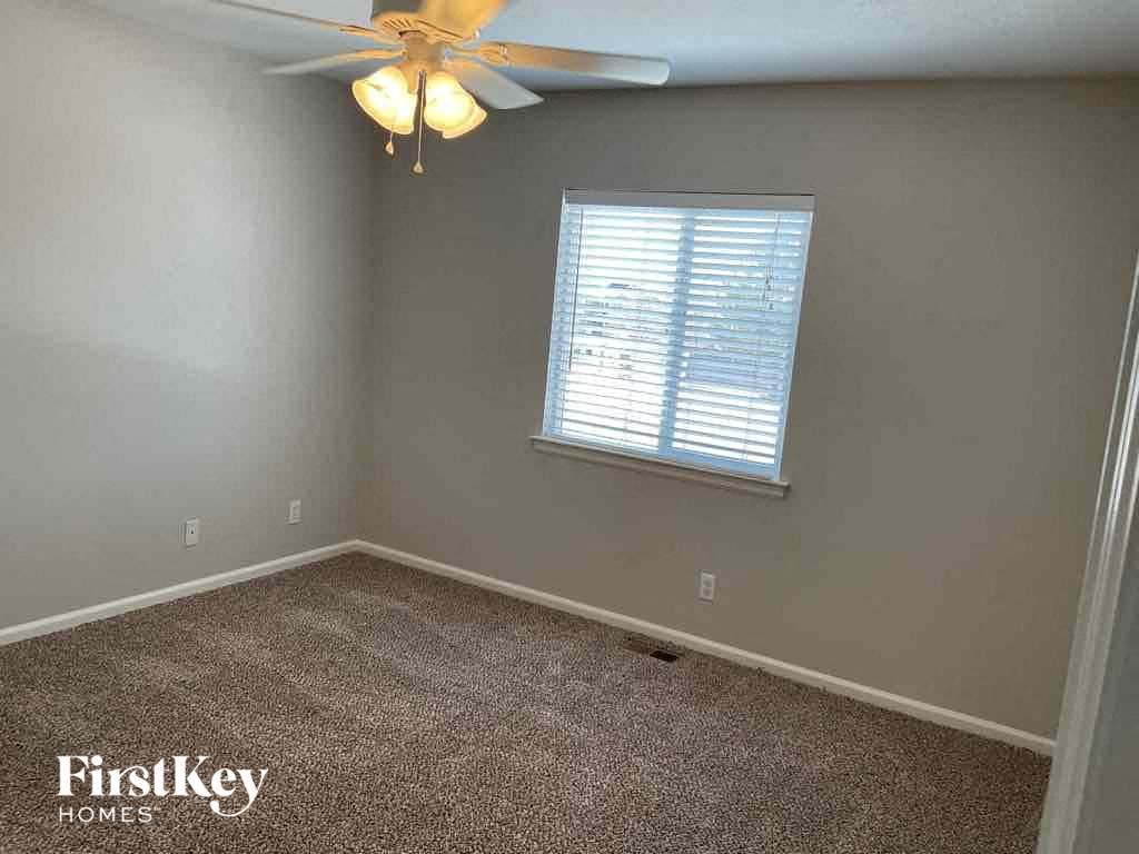 a empty room with a ceiling fan and a window