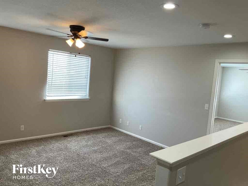 a empty room with a ceiling fan and a window