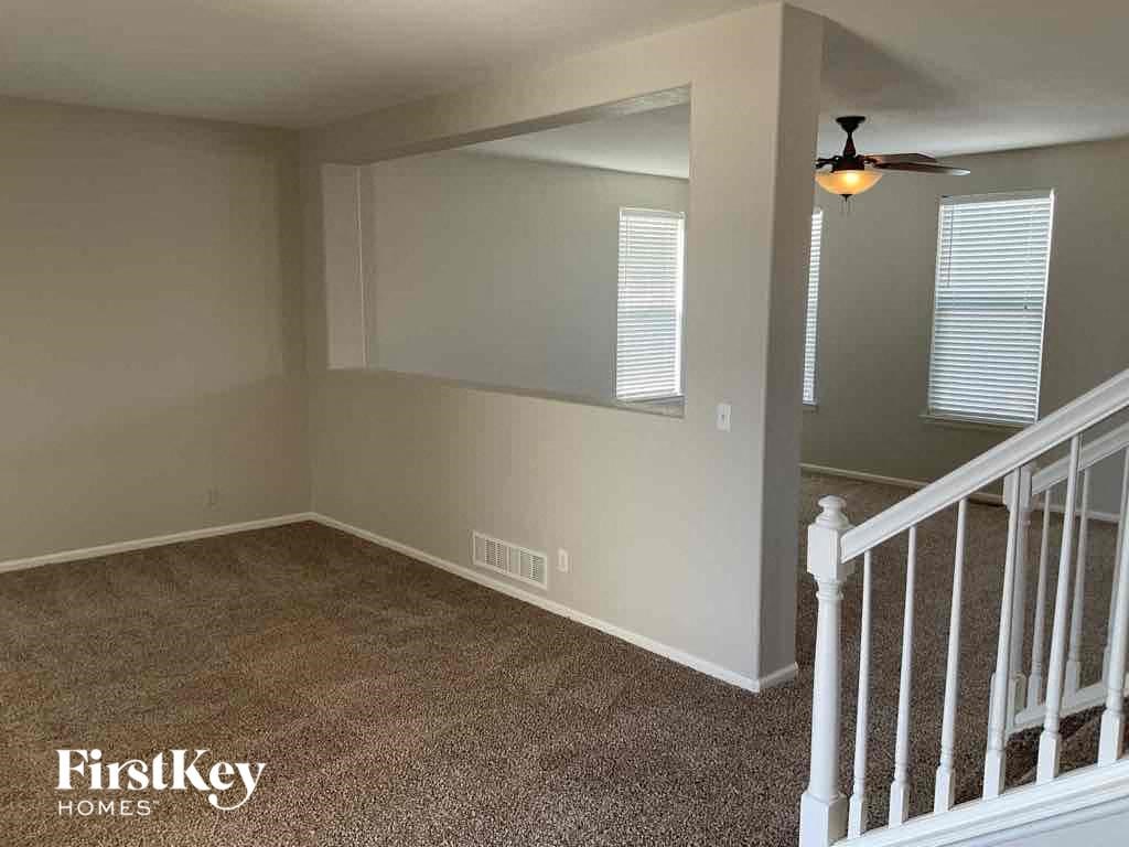 an empty room with a staircase and a ceiling fan