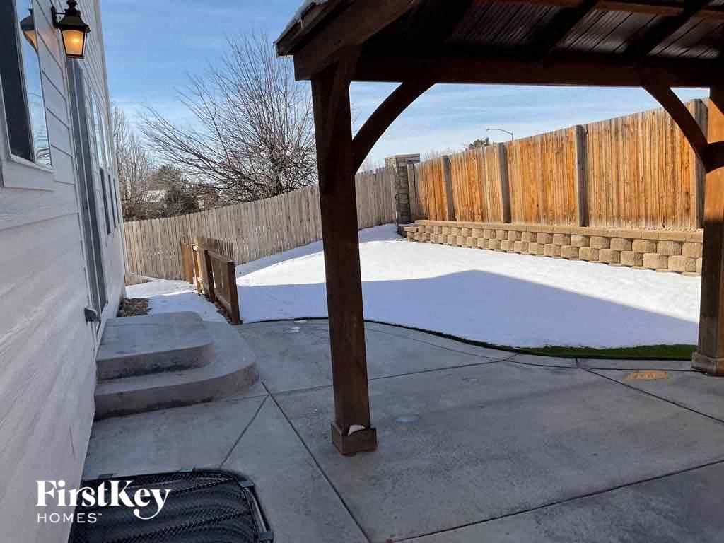 a patio with a wooden fence in the snow