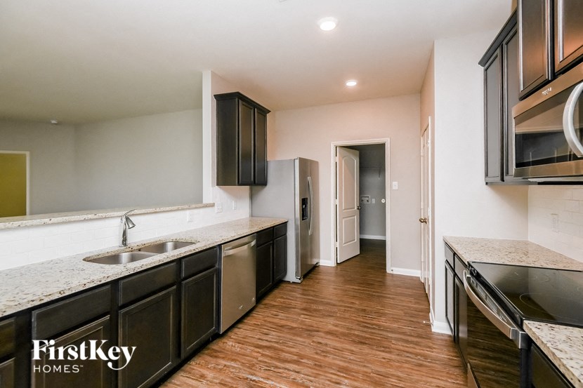 a kitchen with black cabinets and a sink and a refrigerator