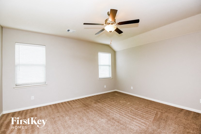 a living room with a ceiling fan and a window