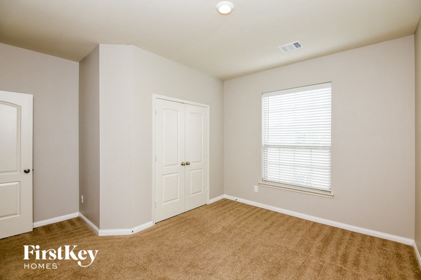 a bedroom with a closet and a window and a door