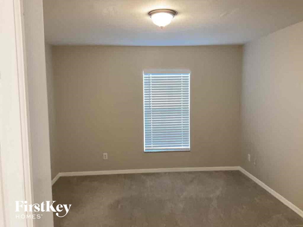 an empty room with a window and a lamp on the ceiling