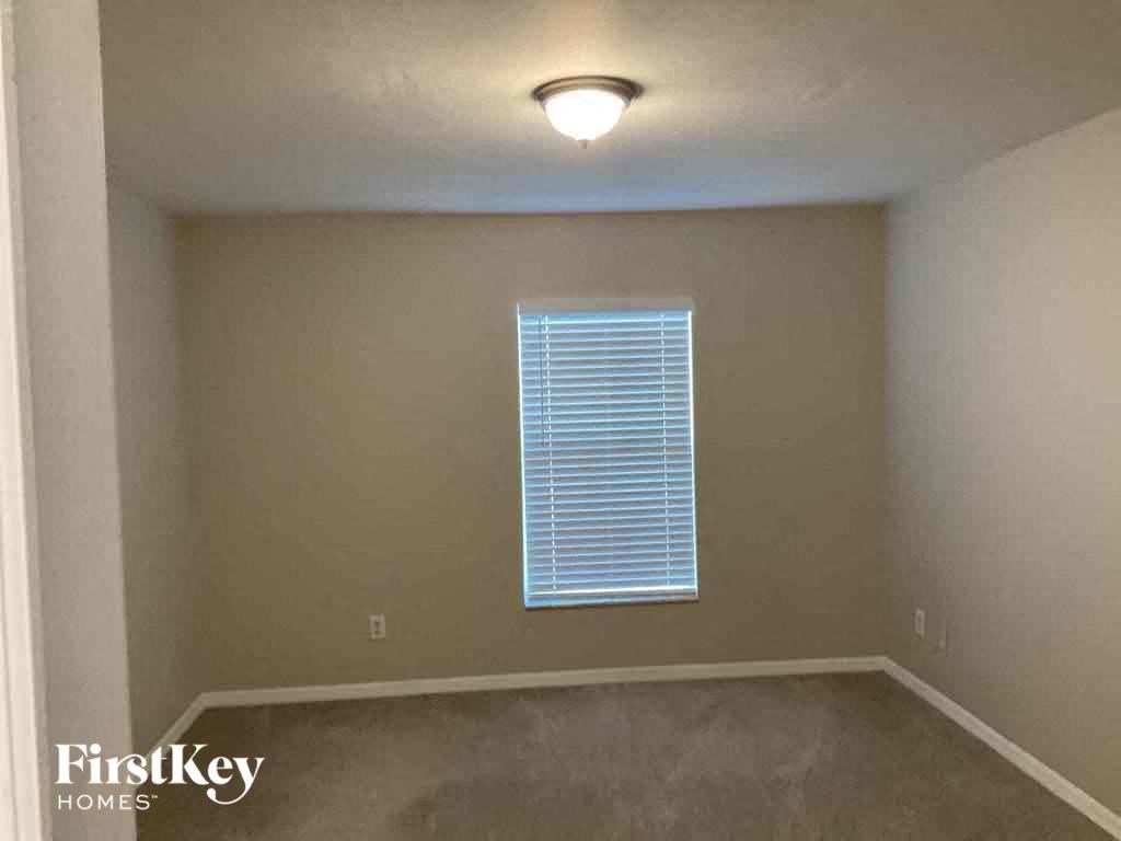 an empty room with a window and a light on the ceiling