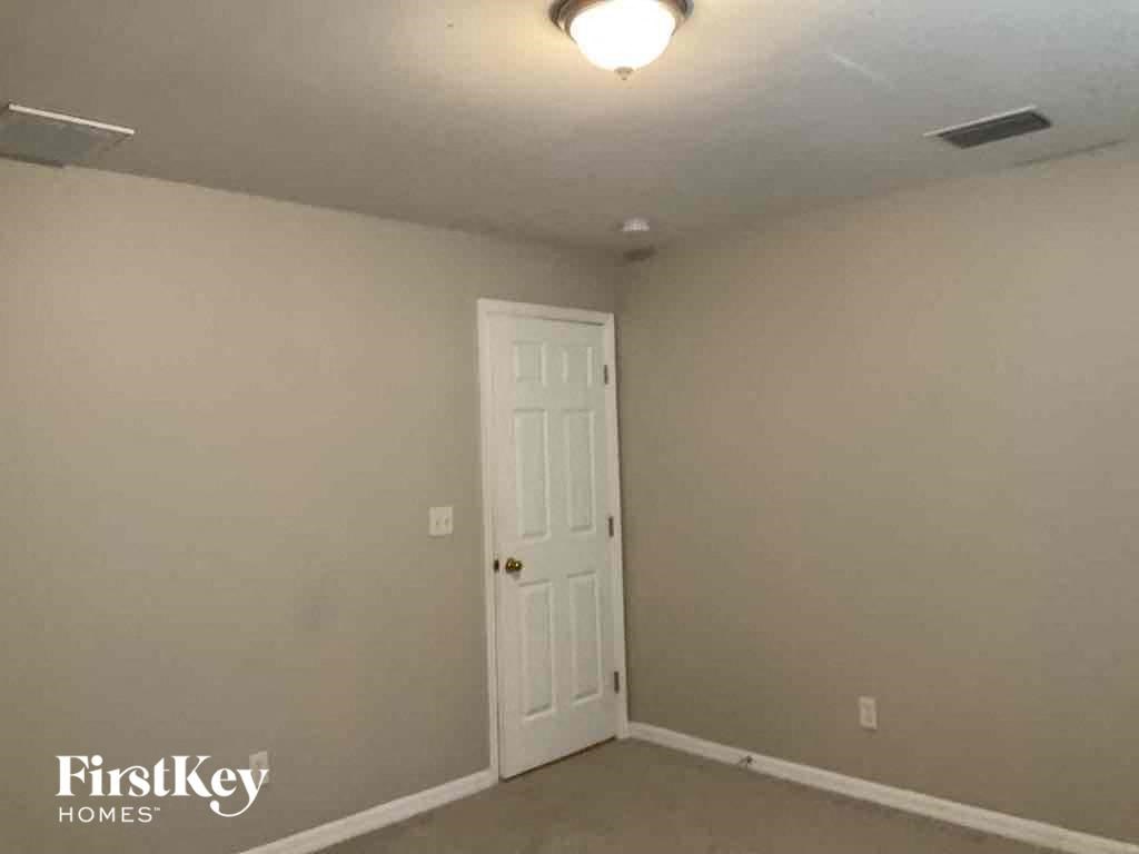 an empty room with a white door and a light on the ceiling
