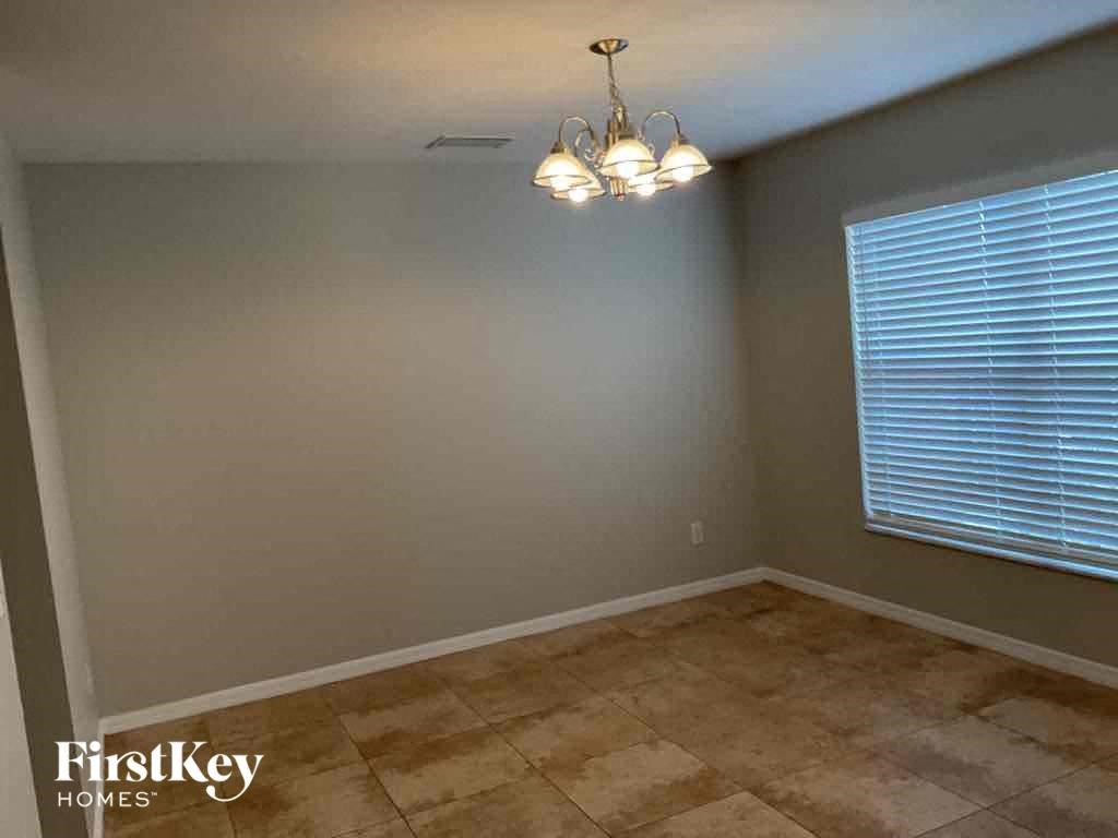 an empty room with a window and a chandelier