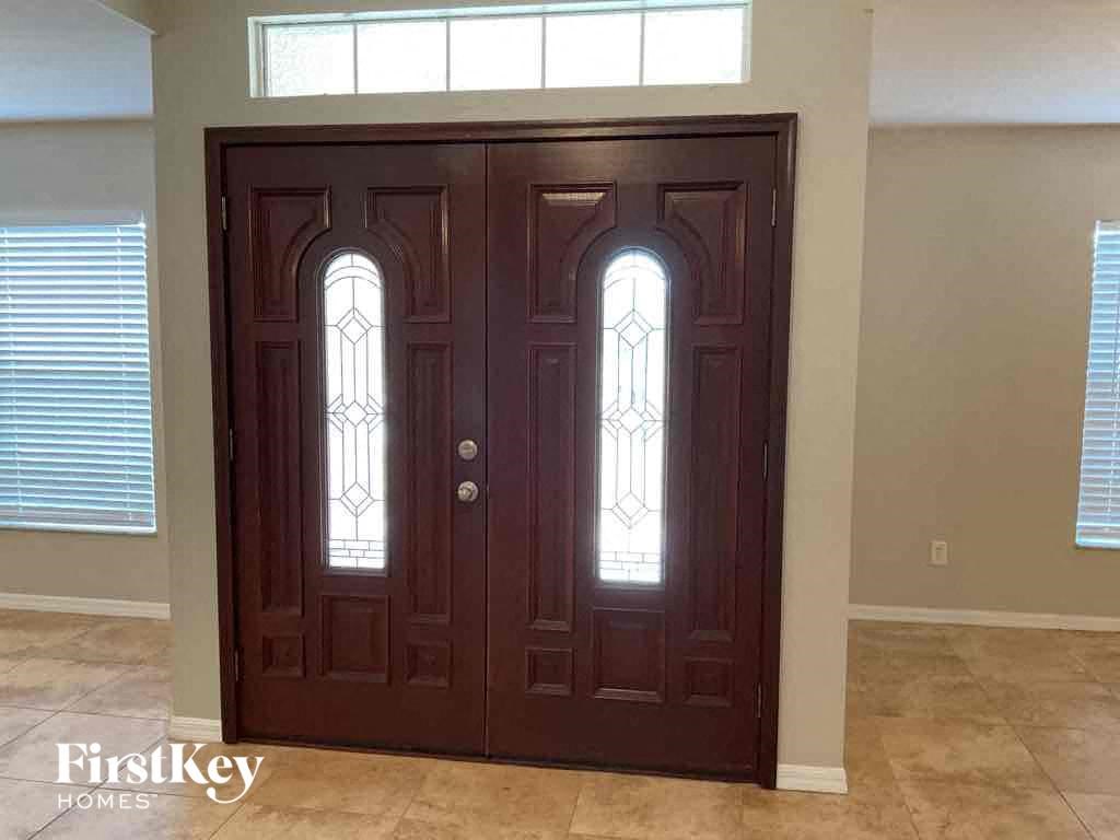 an empty room with a wooden door with windows