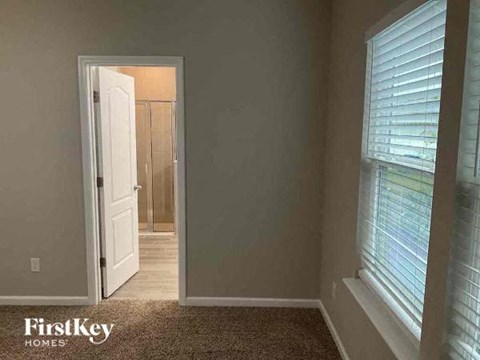 A room with a carpeted floor and a doorway leading to another room.