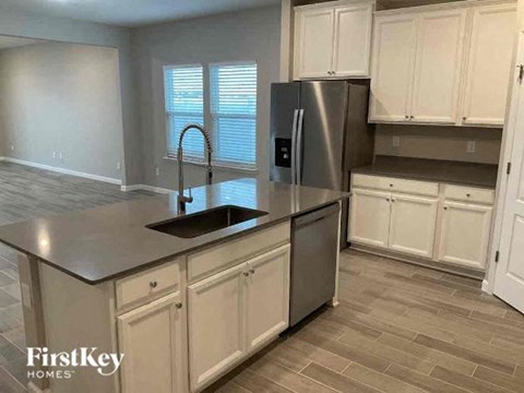 A kitchen with a stainless steel refrigerator and a sink.