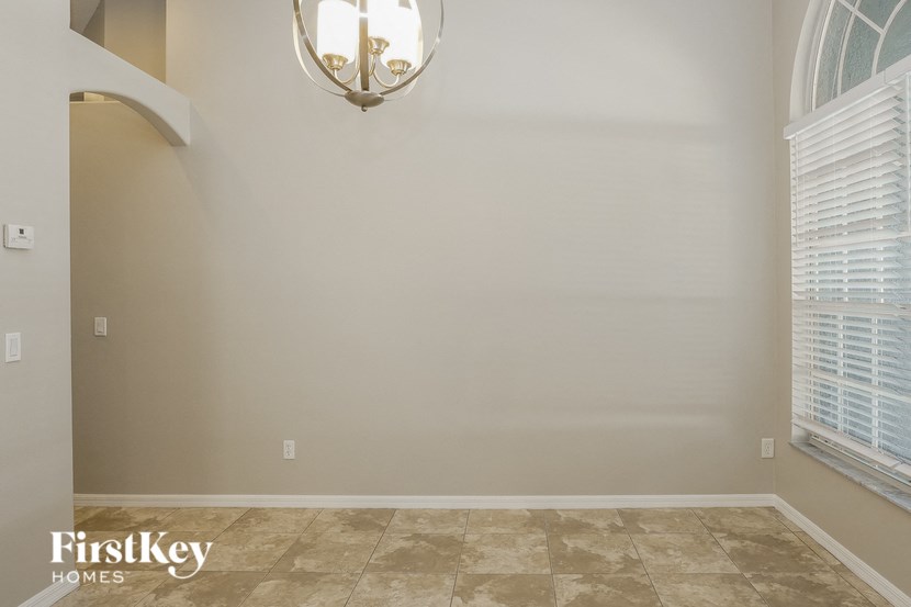a empty living room with a large window and a chandelier