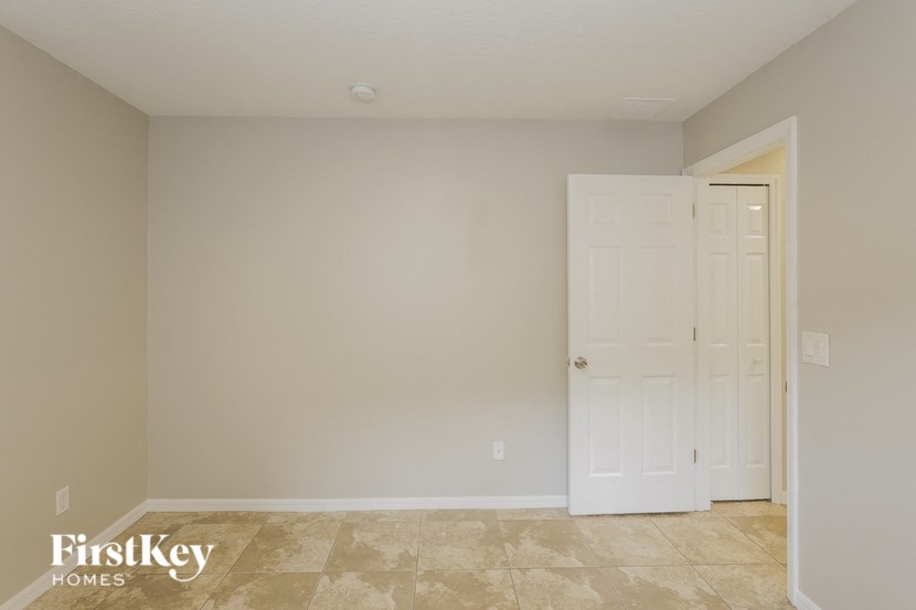 a empty room with a white door and a closet