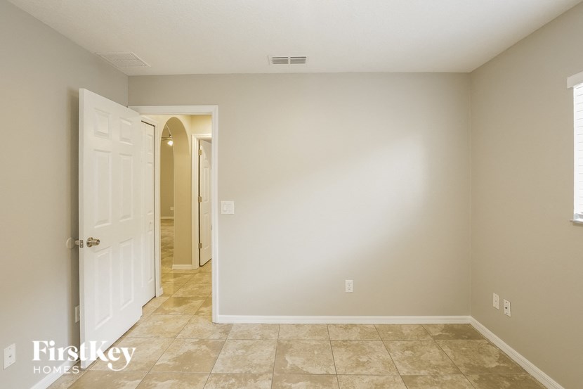 a empty room with a white door and a hallway to a closet