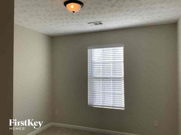 an empty room with a window and a light on the ceiling