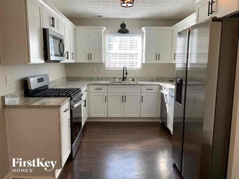 a kitchen with white cabinets and a stainless steel refrigerator