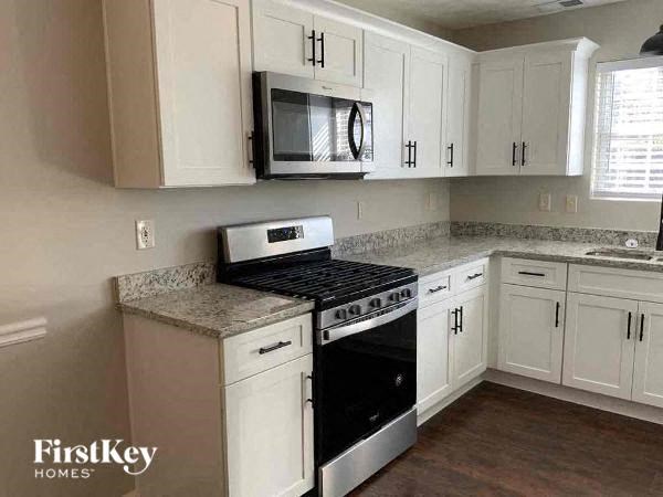 a kitchen with white cabinets and a stove and a microwave