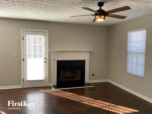 a empty living room with a fireplace and a ceiling fan