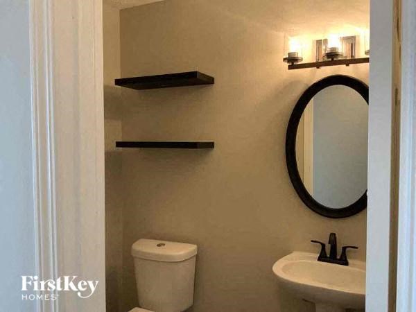 a bathroom with a mirror and a toilet and a sink