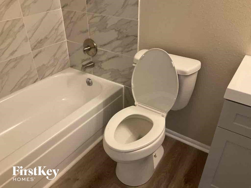 a bathroom with a toilet and a bath tub