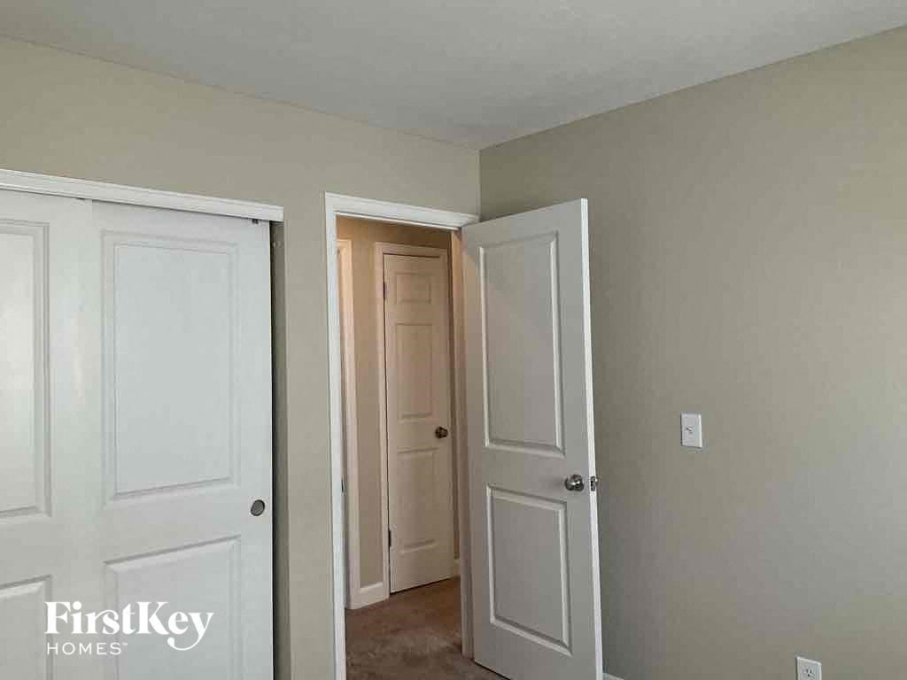 a bedroom with two doors and a closet and a door to a hallway