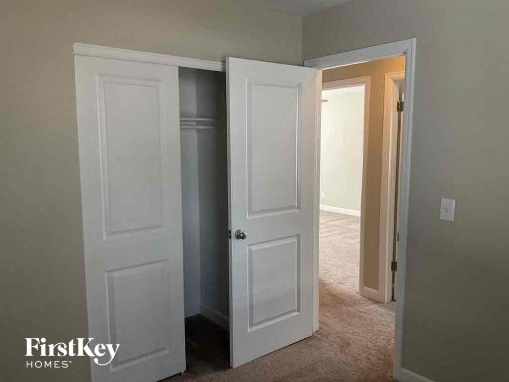a bedroom with two closets and two doors and a carpeted floor