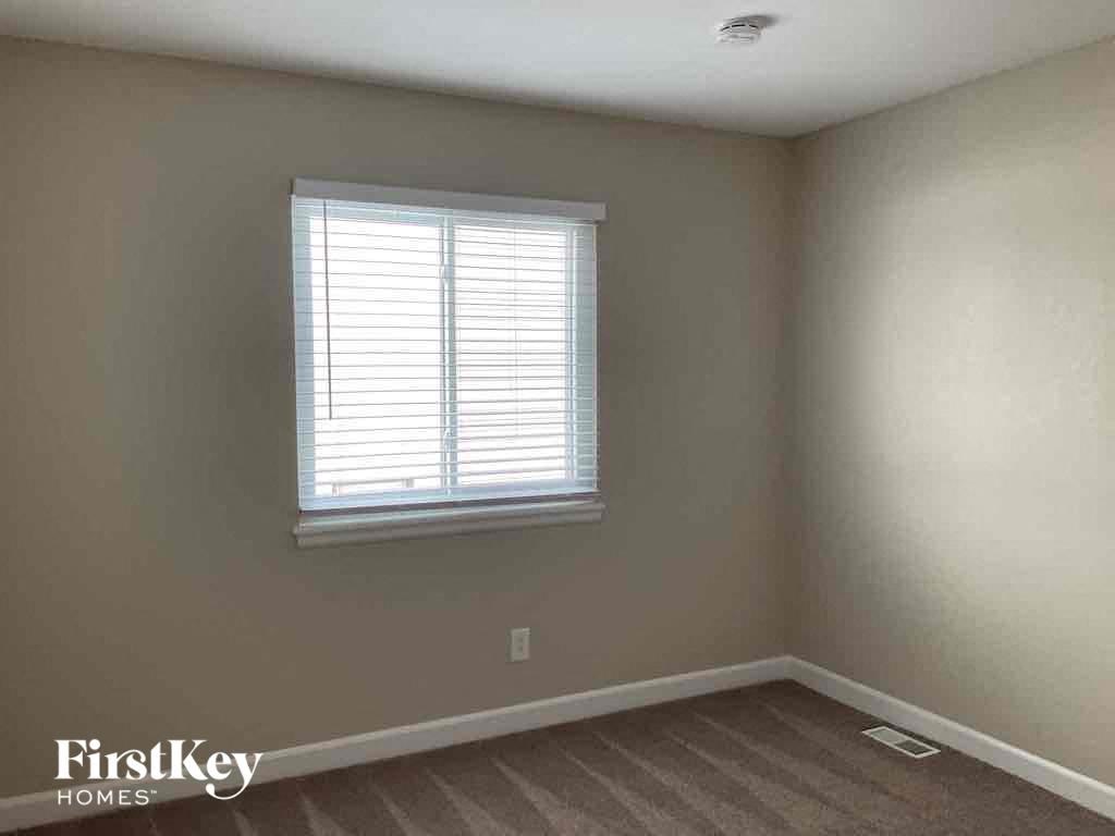 a bedroom with a window and a wooden floor