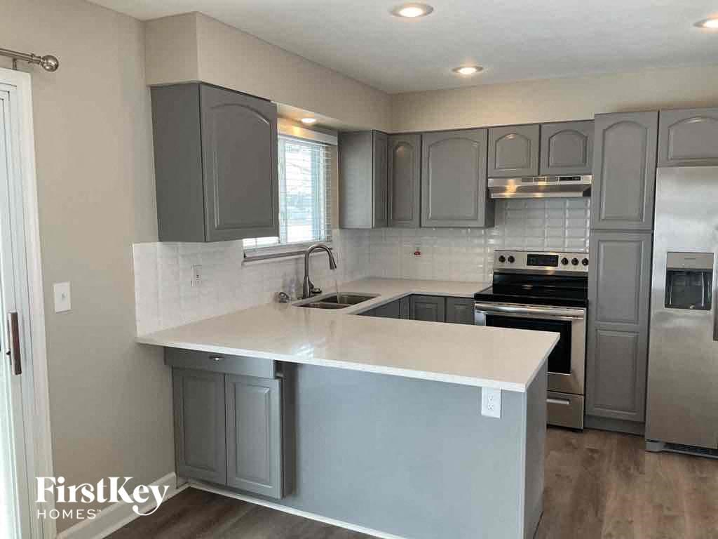 a kitchen with gray cabinets and a white counter top