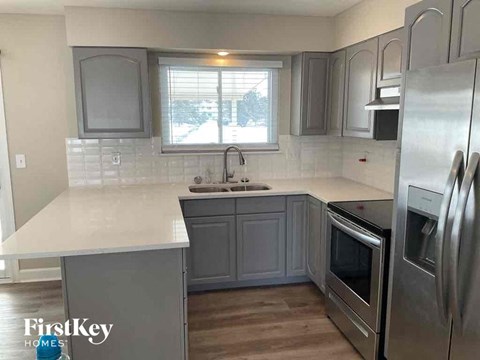 a kitchen with white counter tops and gray cabinets