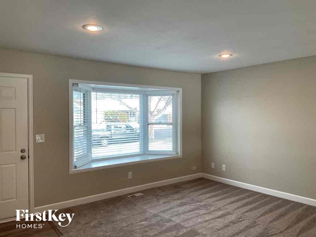 an empty bedroom with a large window and a white door