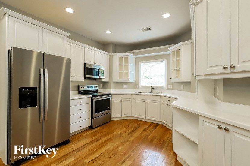 a white kitchen with stainless steel appliances and white cabinets
