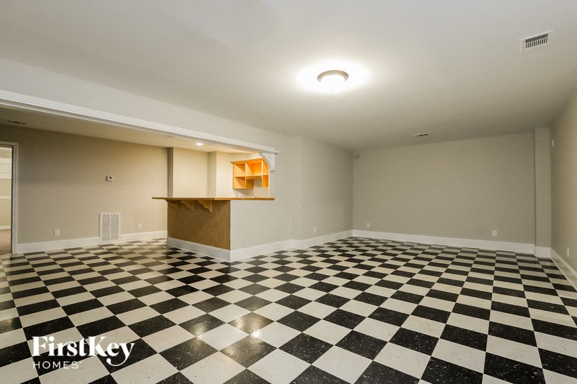 an empty room with a checkered floor and a desk