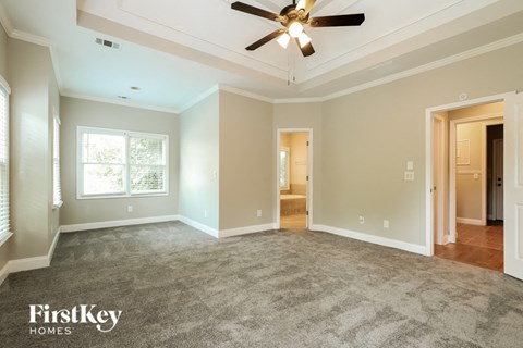 a living room with carpet and a ceiling fan