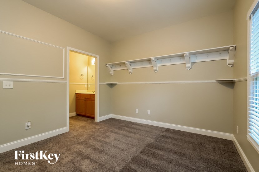 a master bedroom with a carpeted floor and a closet and a bathroom