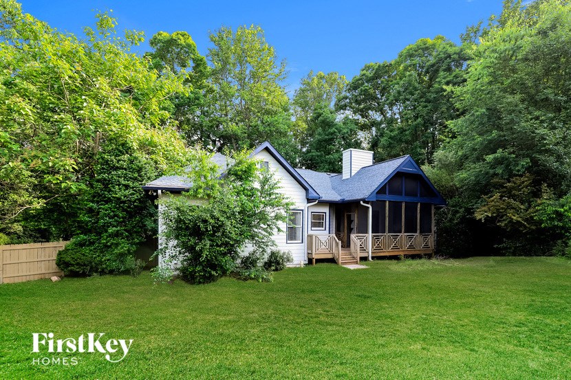a white house with a blue roof on a green lawn