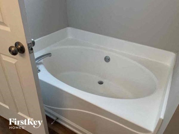 a white bath tub in a bathroom with a door