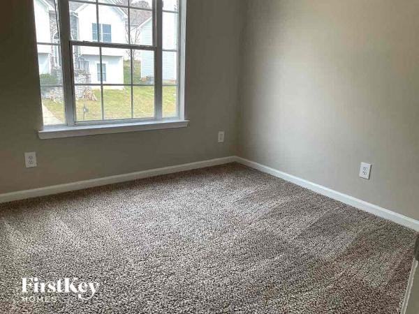 an empty room with a window and a carpeted floor