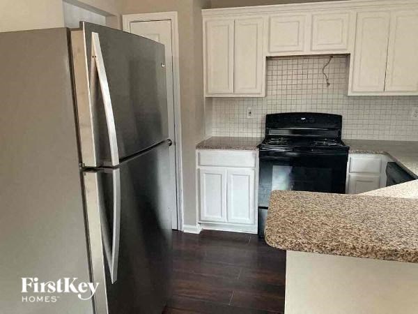 a kitchen with a black stove and a refrigerator