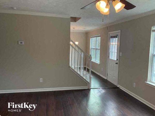 a empty living room with a staircase and a door