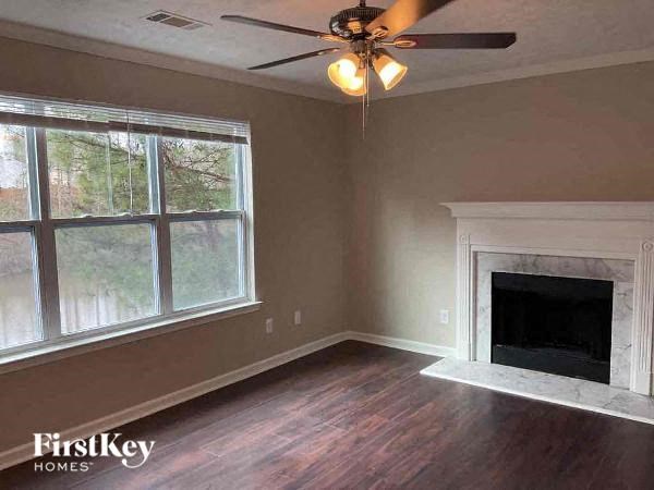 a living room with a fireplace and a ceiling fan