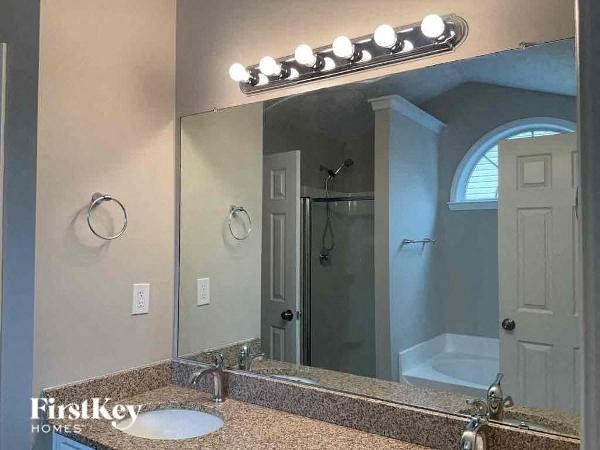 a bathroom with a mirror and a shower and a sink