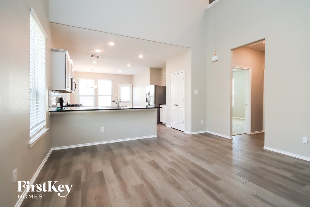 the living room and kitchen of an apartment with hardwood flooring