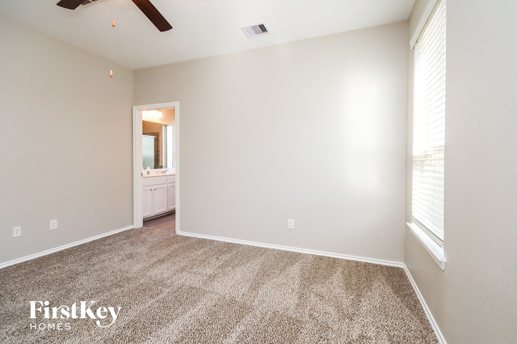 an empty living room with carpet and a large window