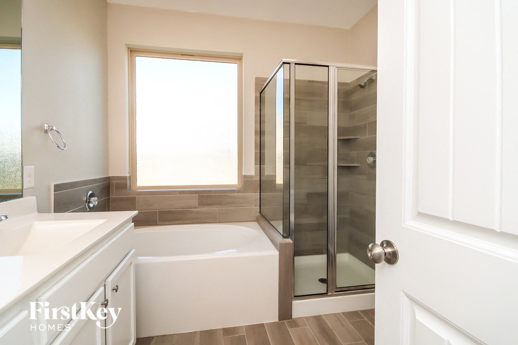 a bathroom with a tub and a shower and a sink